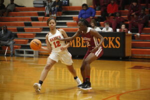 Two girls playing basketball on a court