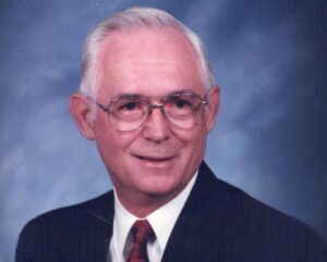A man in suit and tie with glasses.