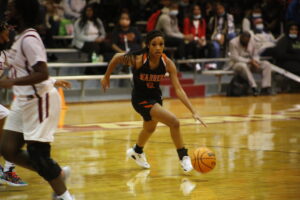 A girl dribbles the ball during a basketball game.