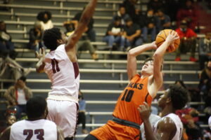 A group of men playing basketball on a court.