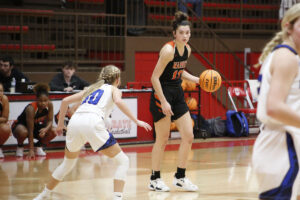 A girl in black shirt holding a basketball.