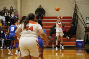 A girl is playing basketball in the middle of a game.