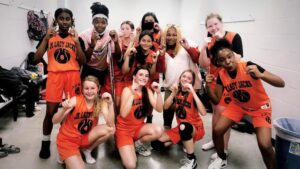 A group of girls in orange and black outfits.