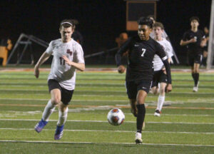 A group of young men playing soccer on a field.