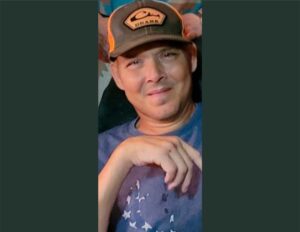 A man wearing an orange and brown hat.