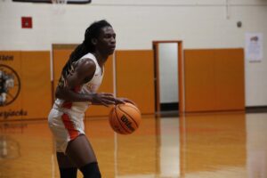 A woman holding onto a basketball on the court
