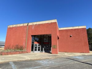 A red brick building with an entrance to the side of it.