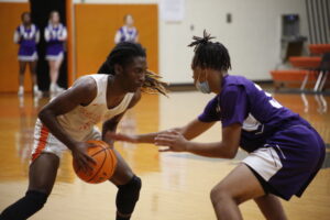 Two men playing basketball on a court with one holding the ball.