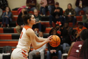 A girl in the middle of a basketball game.