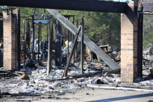 A fire destroyed building with debris scattered around it.