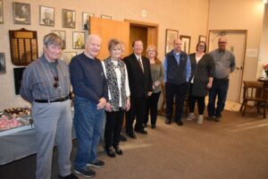 A group of people standing in front of pictures.