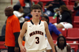 A young man in white jersey holding basketball.