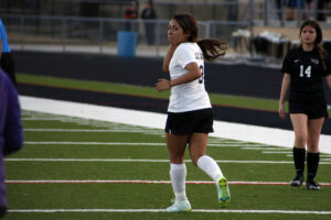 A female soccer player running on the field