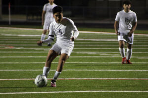 A group of young men playing soccer on a field.