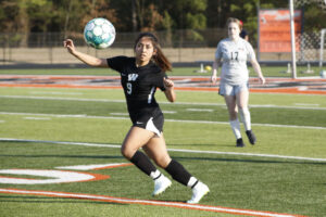 A girl is running with the ball in her hand.