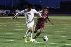 Two men playing soccer on a field.