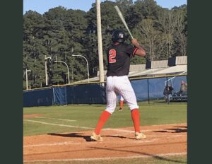 A baseball player is holding his bat ready to swing.