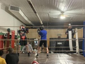 A group of people in the ring with boxing gloves on.