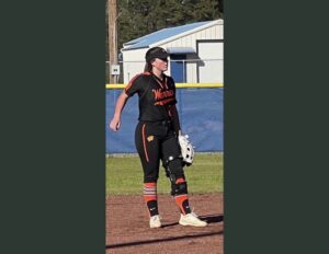 A woman in black and orange baseball uniform.