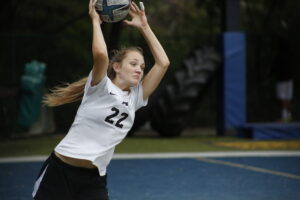 A woman is playing softball on the court