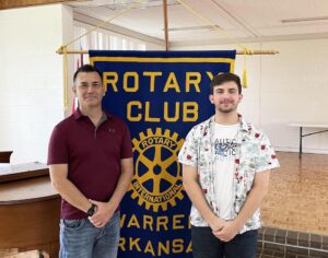 Two men standing in front of a banner.