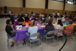 A group of people sitting at tables eating food.