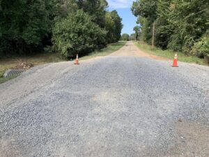 A road with cones blocking the way to the side of it.