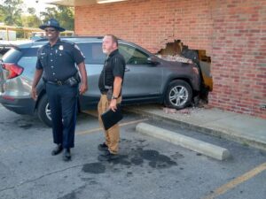 A police officer and another man standing in front of an suv.