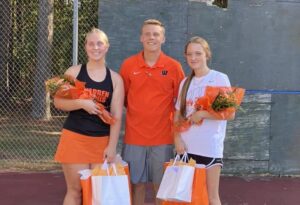 Three girls holding bags and a tennis ball