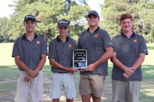 A group of men holding up a plaque.