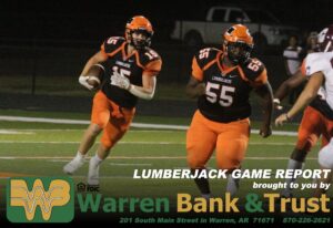 Two football players are running on a field.