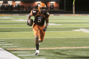A football player running with the ball on a field.