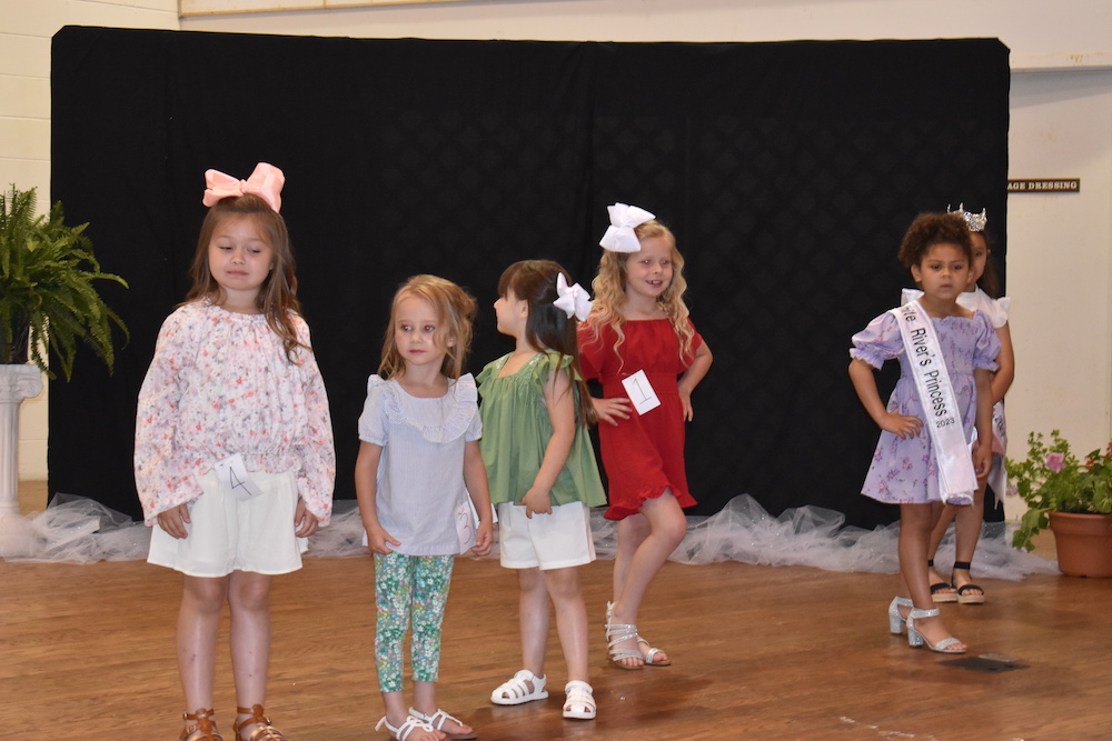 A group of little girls standing on the stage