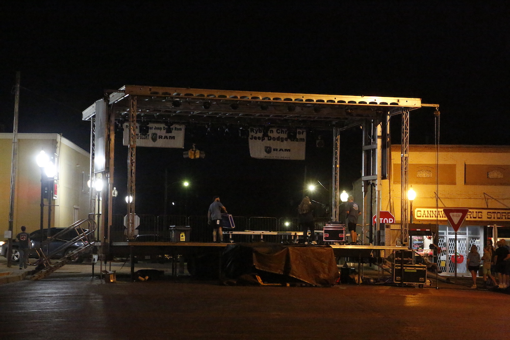 A man standing next to some ropes and a horse.