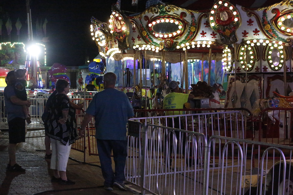 A man standing next to some ropes and a horse.