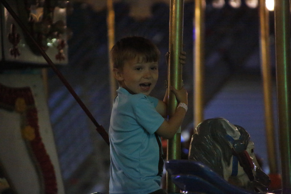 A man standing next to some ropes and a horse.
