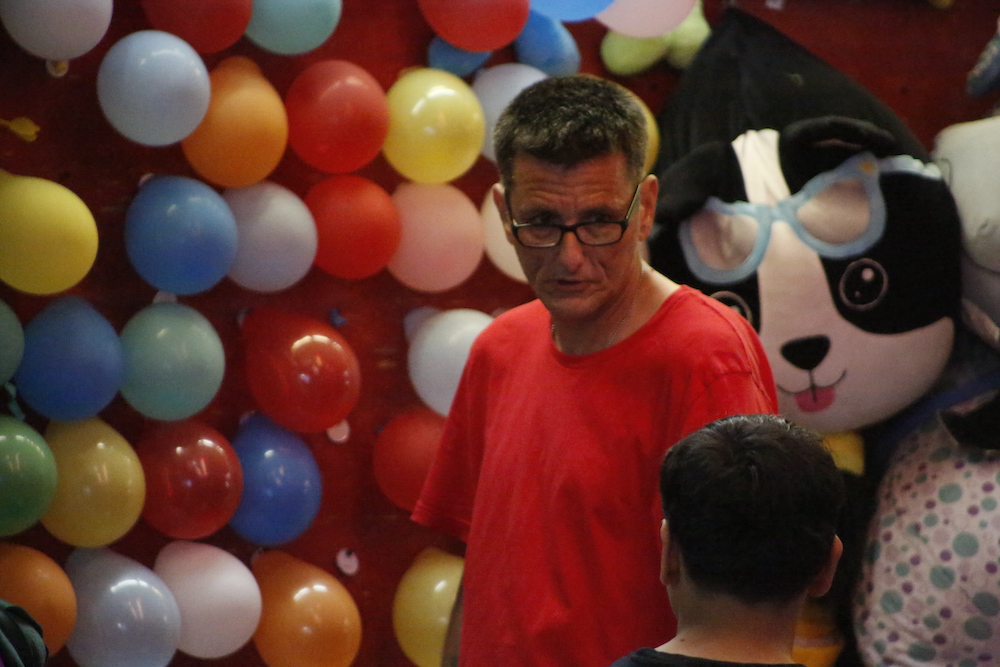 A man standing next to some ropes and a horse.