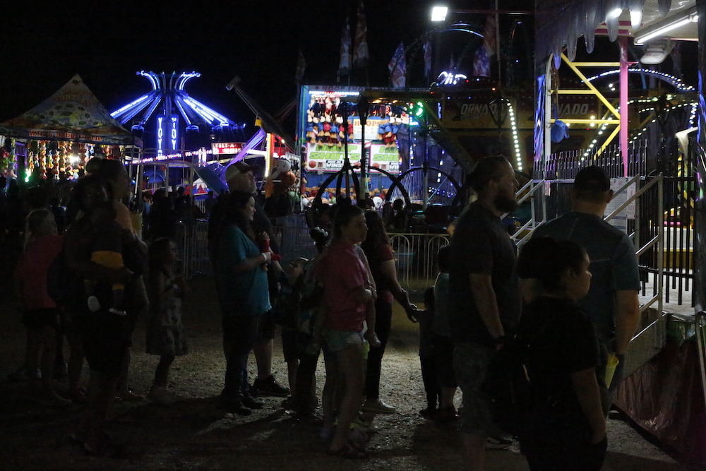 A man standing next to some ropes and a horse.