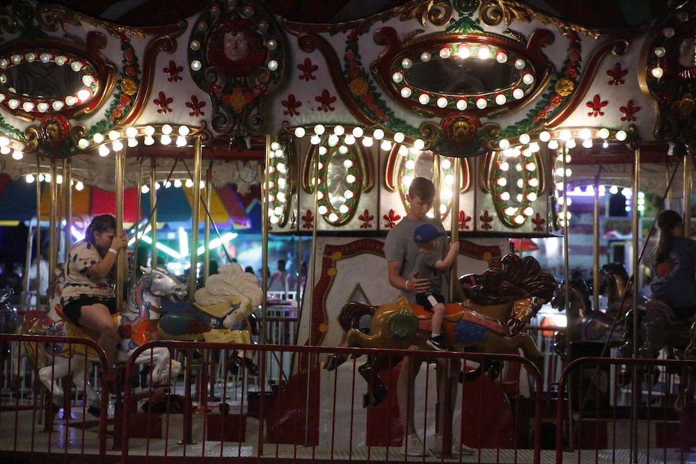 A man standing next to some ropes and a horse.