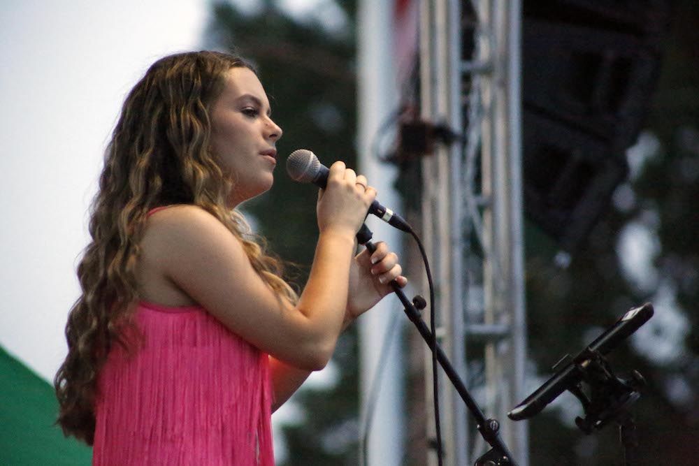 A man standing next to some ropes and a horse.