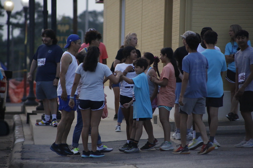 A man standing next to some ropes and a horse.