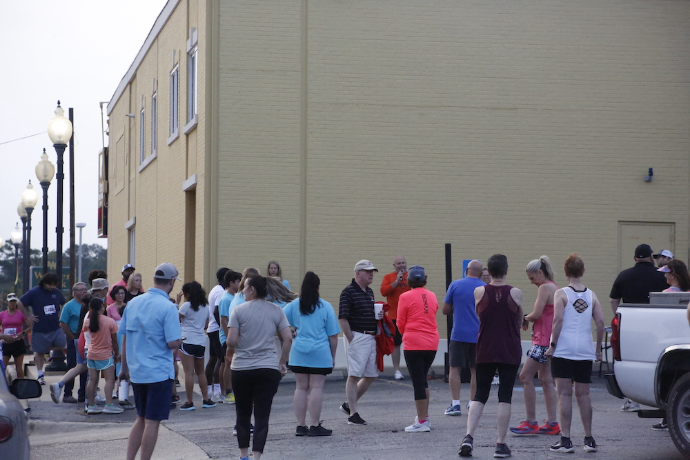 A man standing next to some ropes and a horse.