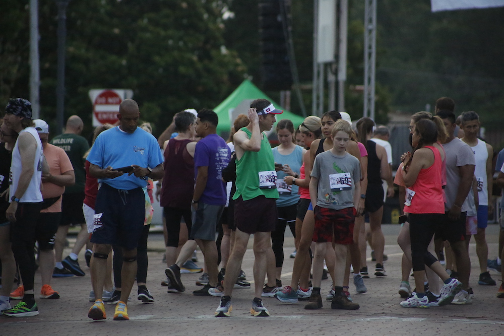 A man standing next to some ropes and a horse.