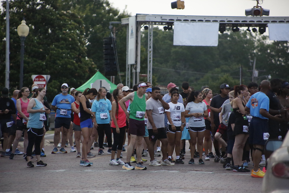 A man standing next to some ropes and a horse.