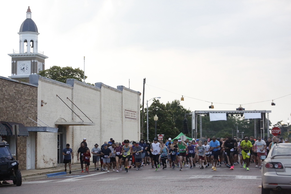 A man standing next to some ropes and a horse.