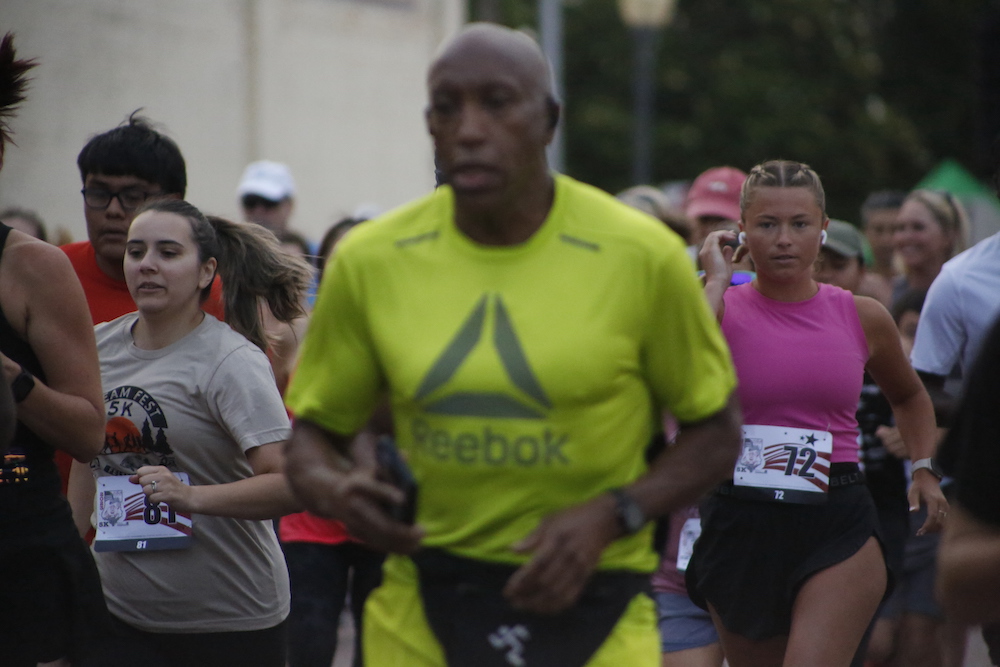 A man standing next to some ropes and a horse.