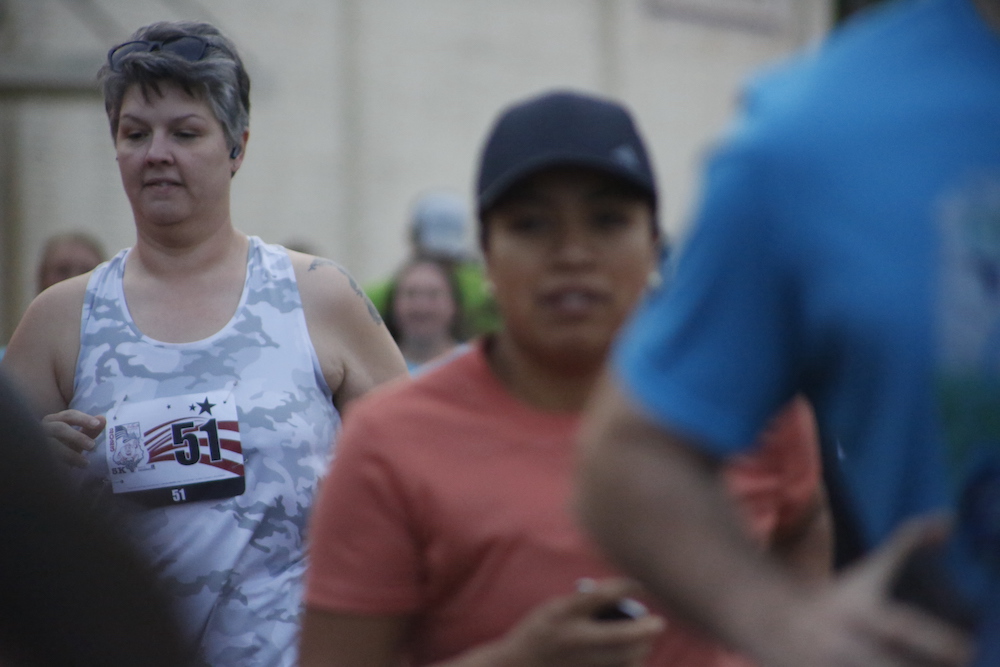 A man standing next to some ropes and a horse.
