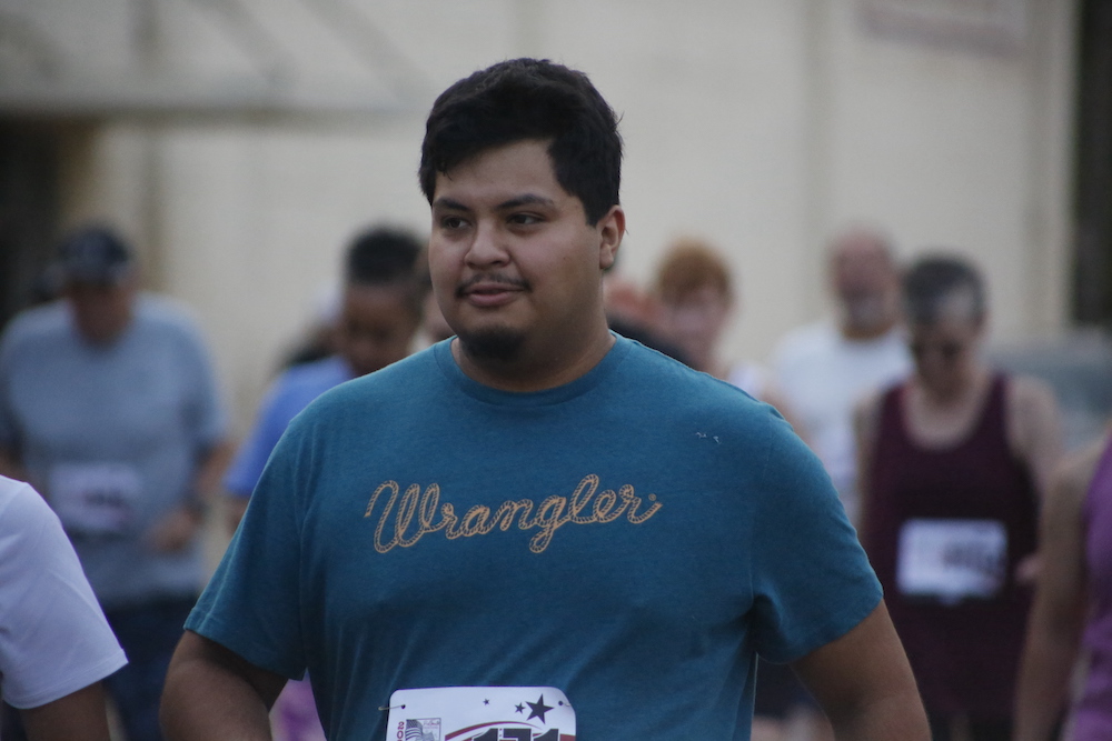 A man standing next to some ropes and a horse.