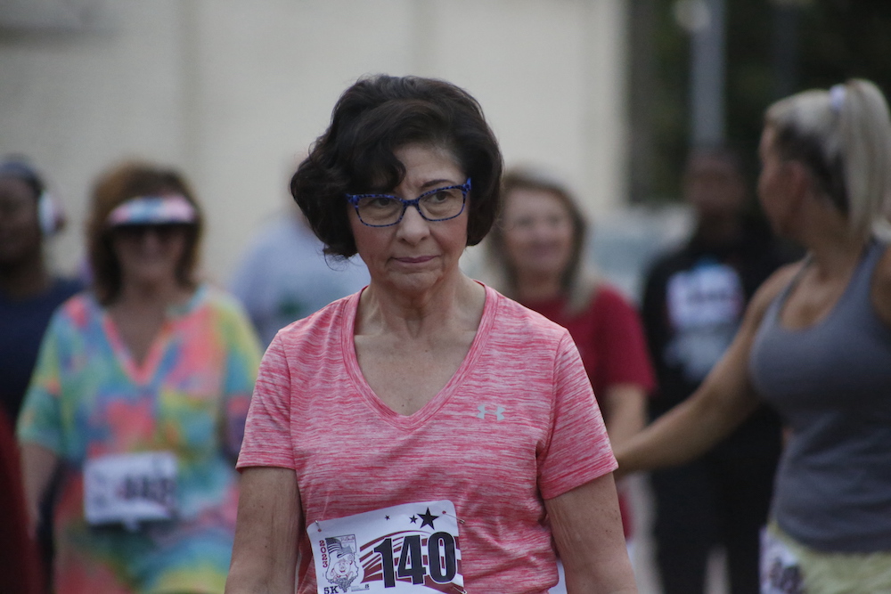 A man standing next to some ropes and a horse.