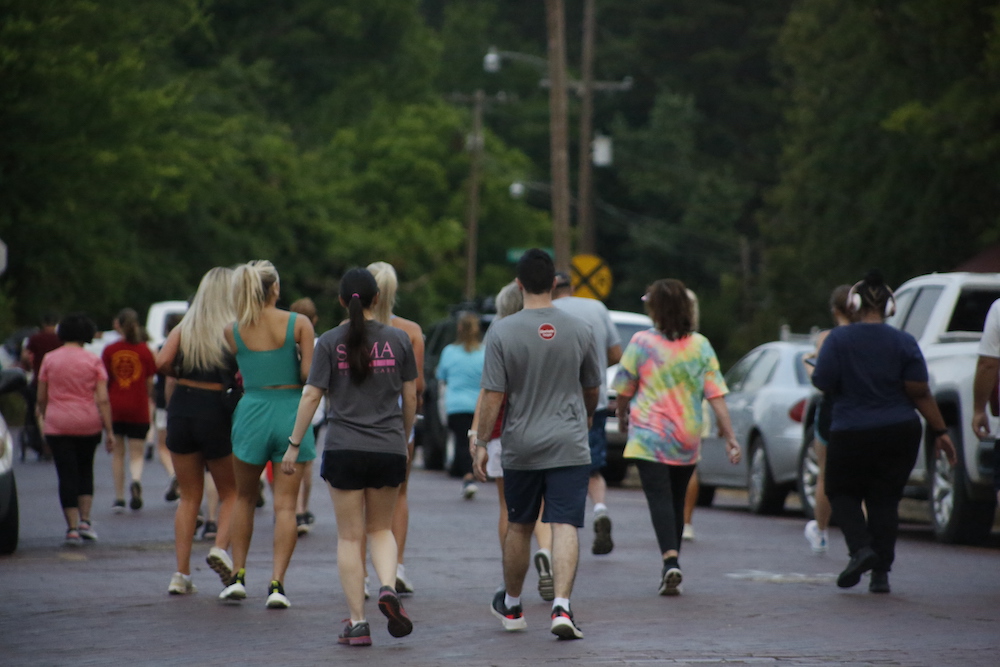 A man standing next to some ropes and a horse.